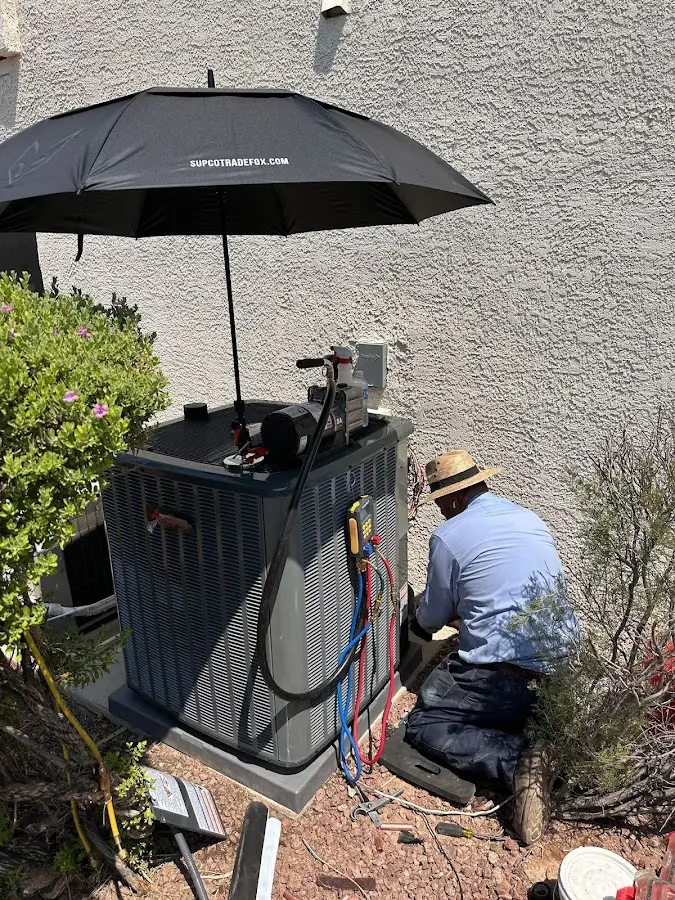 HVAC technician performing outdoor AC maintenance in Raymondville